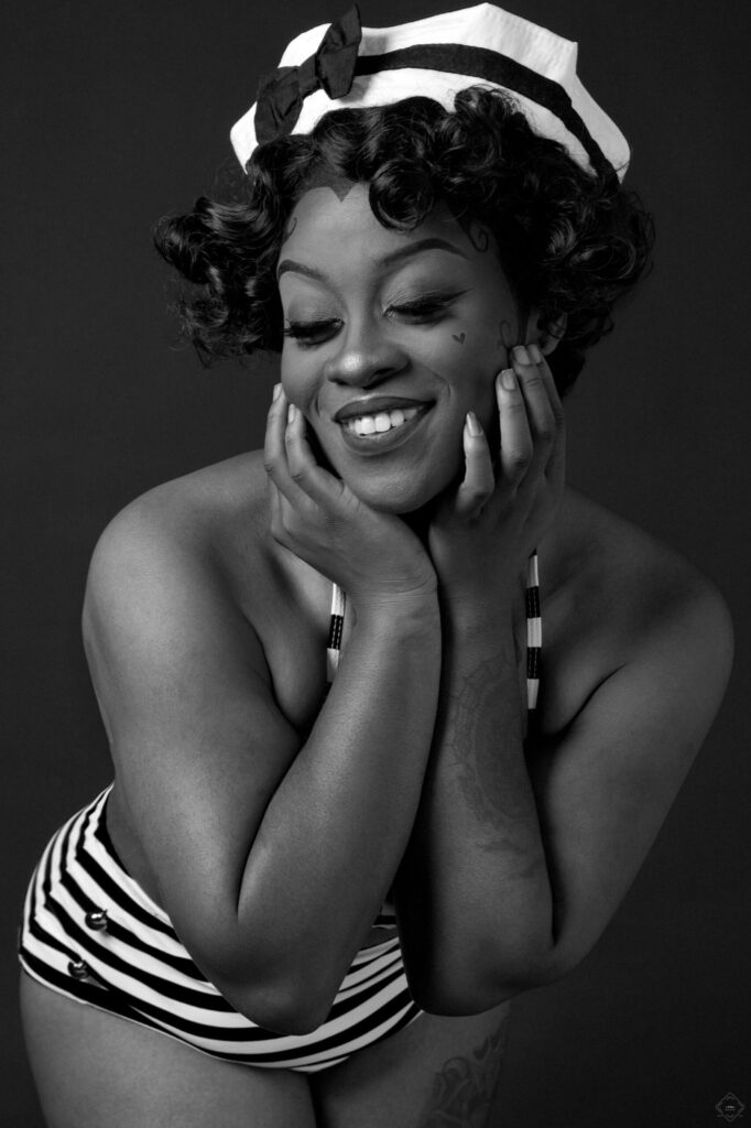 Black tattooed woman posing and smiling for her Pin Up Style photo session