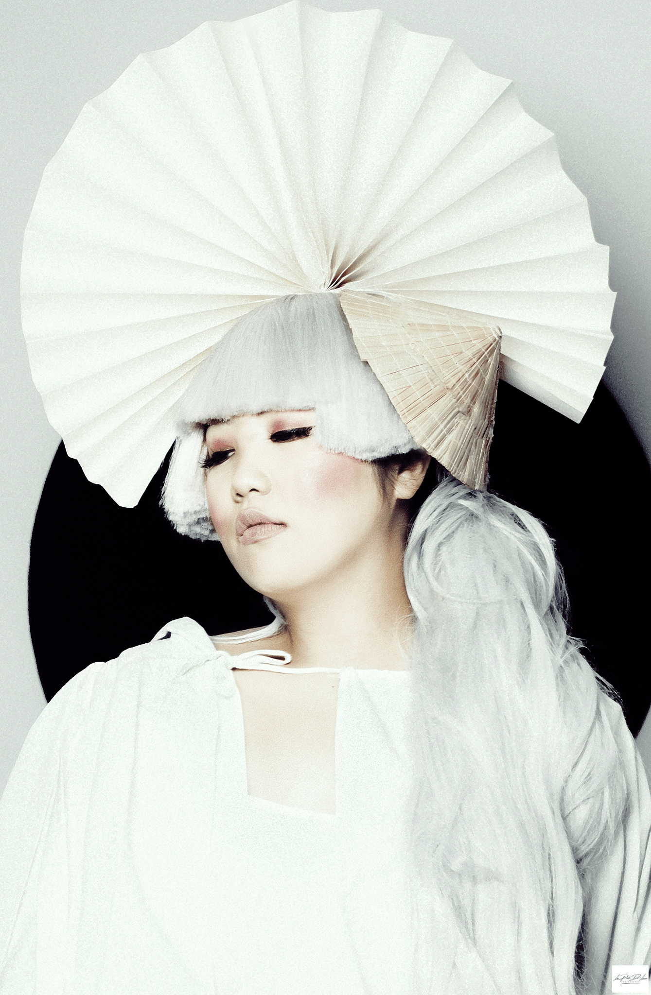Asian woman with pale skin and white wig posing for an avantgarde shoot