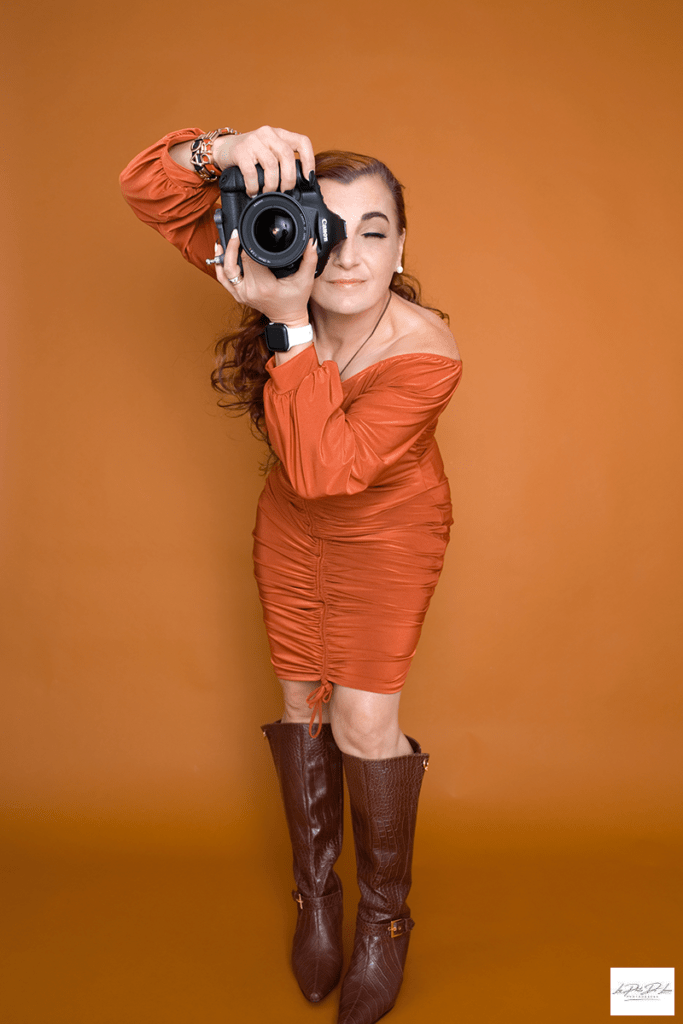 Photographer holding camera while posing for her personal branding shot