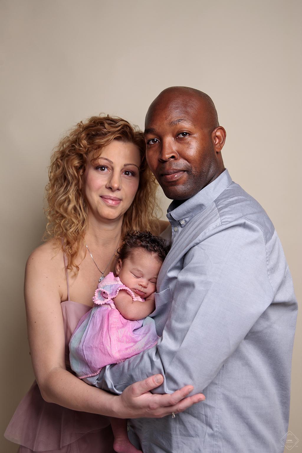 Mixed couple posing with their new baby girl