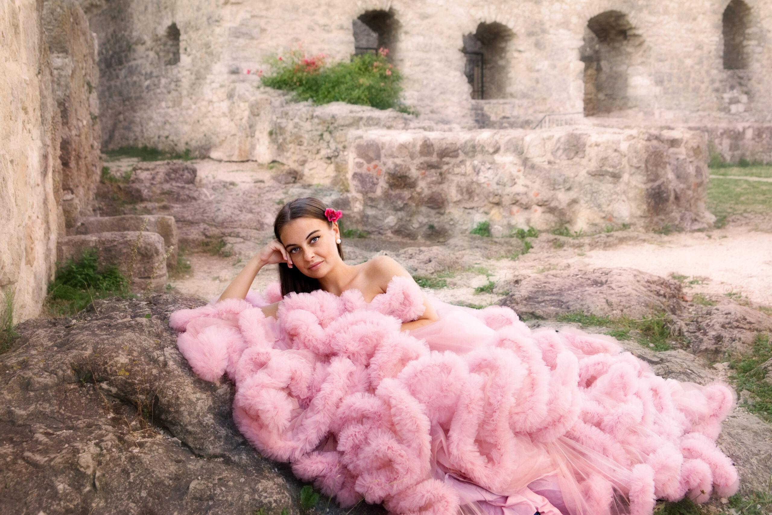Beautiful young woman laying on rocks at a castle site in Germany